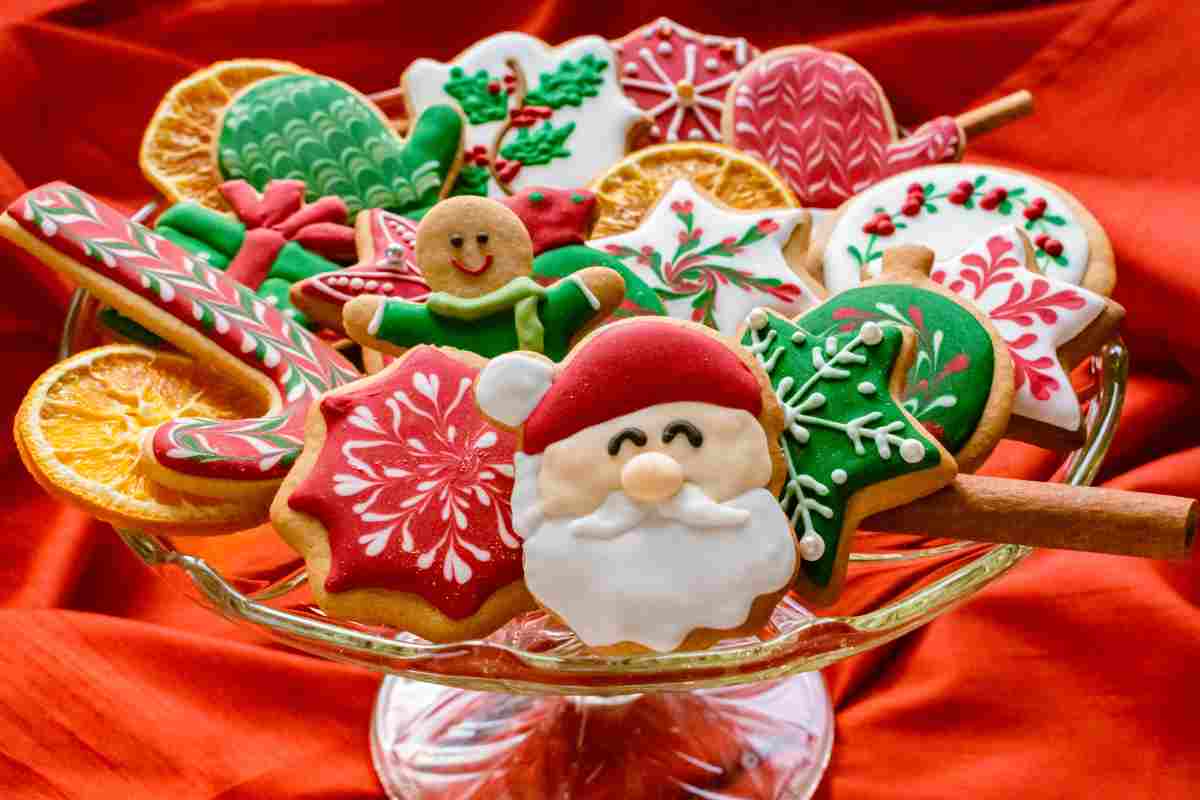 biscotti Natale decorati assortiti su tavola con tovaglia rossa