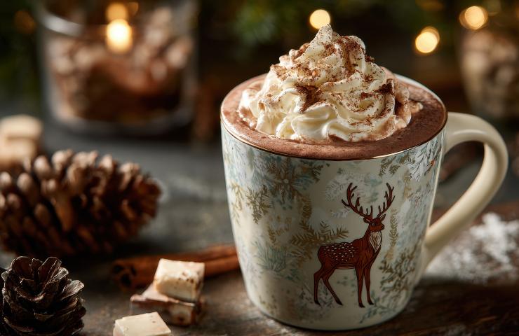 Cioccolata calda natalizia in una tazza a tema con decorazioni di Natale