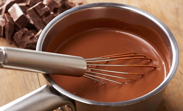 pentolino con cioccolata calda e frusta a mano
