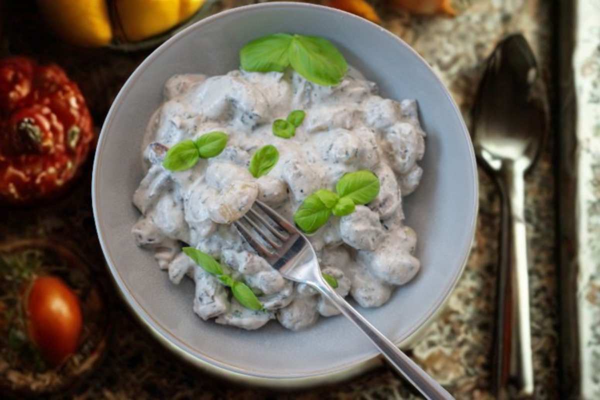 gnocchi con una salsa bianca cremosissima e sopra delle foglie di basilico