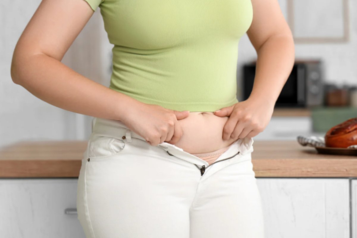donna che si strizza i rotolini di grasso sulla pancia