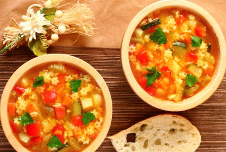 due piatti di minestrone con accanto una fetta di pane