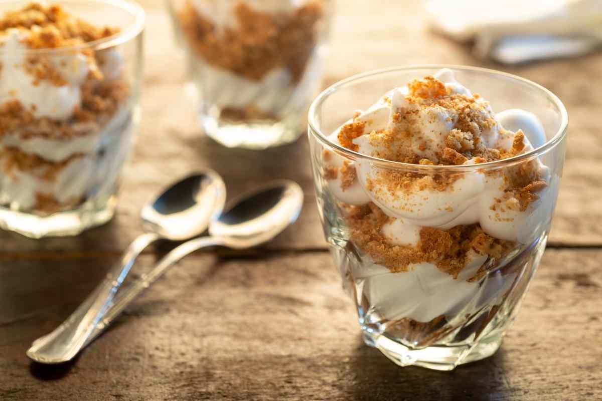 mousse allo yogurt e miele con crumble di biscotti in dei bicchierini su un tavolo