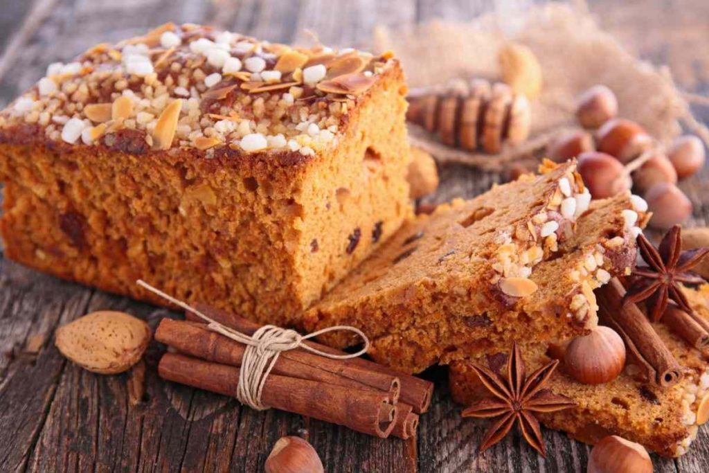 plumcake tagliato a metà con frutta secca e cannella sul tavolo