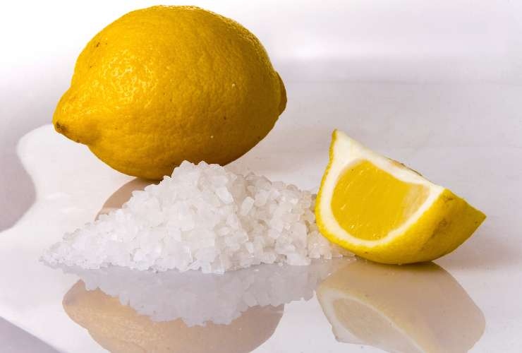 un limone intero, una fetta di limone e sale