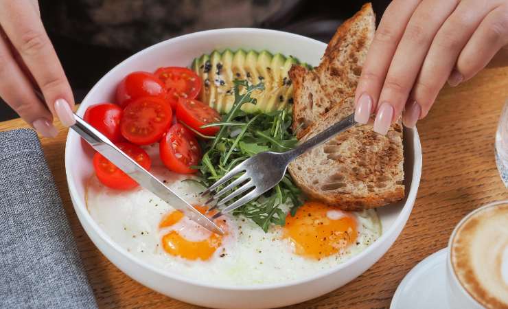 piatto con uova pomodori rucola avocado pane integrale