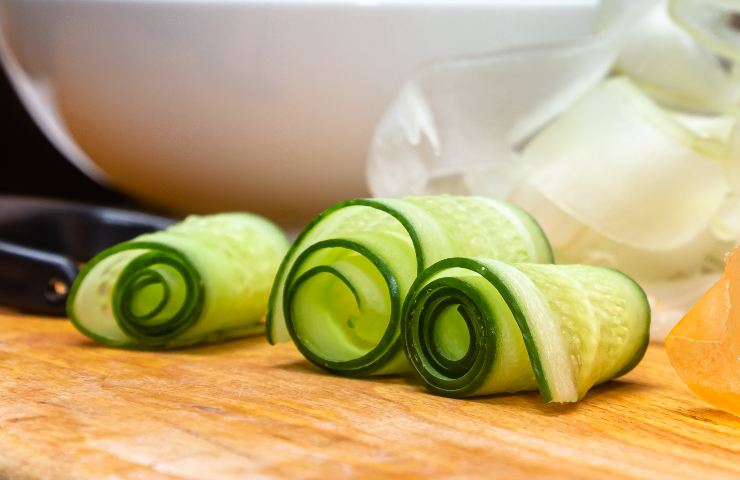 Fette sottili di cetriolo arrotolate su un tavolo di legno