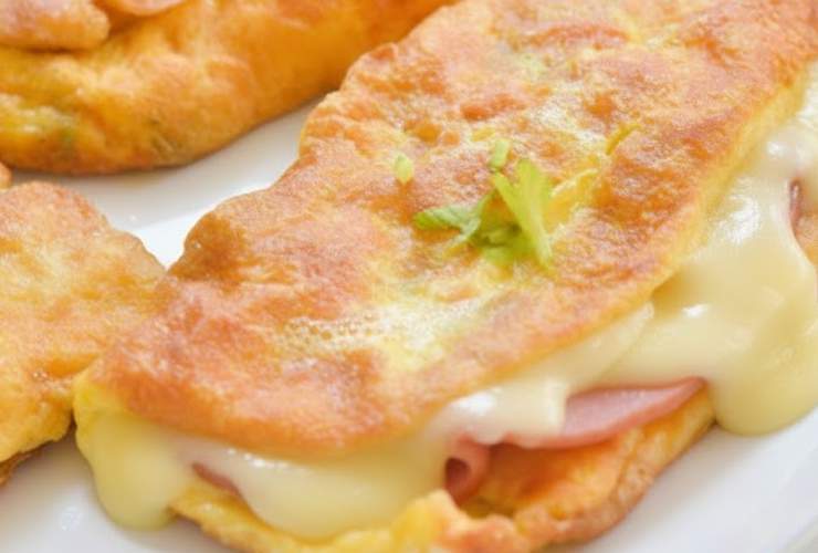 frittata dorata imbottita con prosciutto e formaggio filante