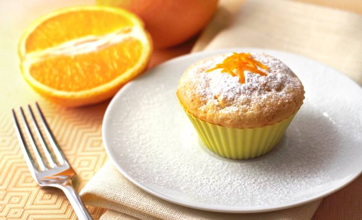 piattino con muffin arancia e zucchero a velo
