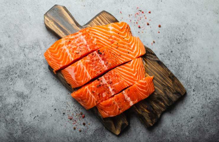 Filetti di salmone crudi su un tagliere