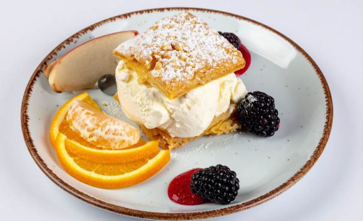 piatto con dolcetto di pasta sfoglia ripieno di crema chantilly