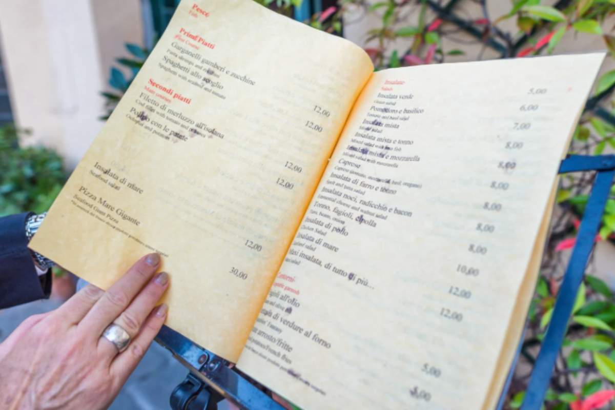 donna che legge il menù al ristorante