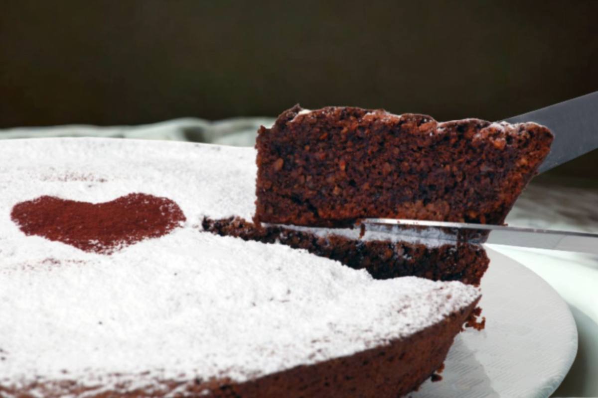 persona che taglia una fetta di torta al cioccolato