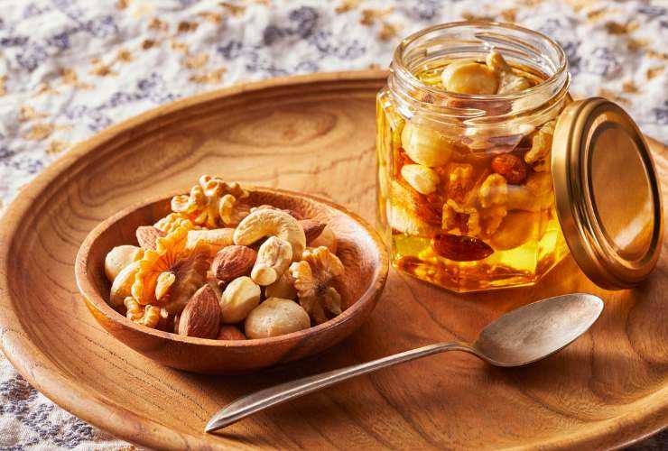ciotola con frutta secca e vasetto di miele