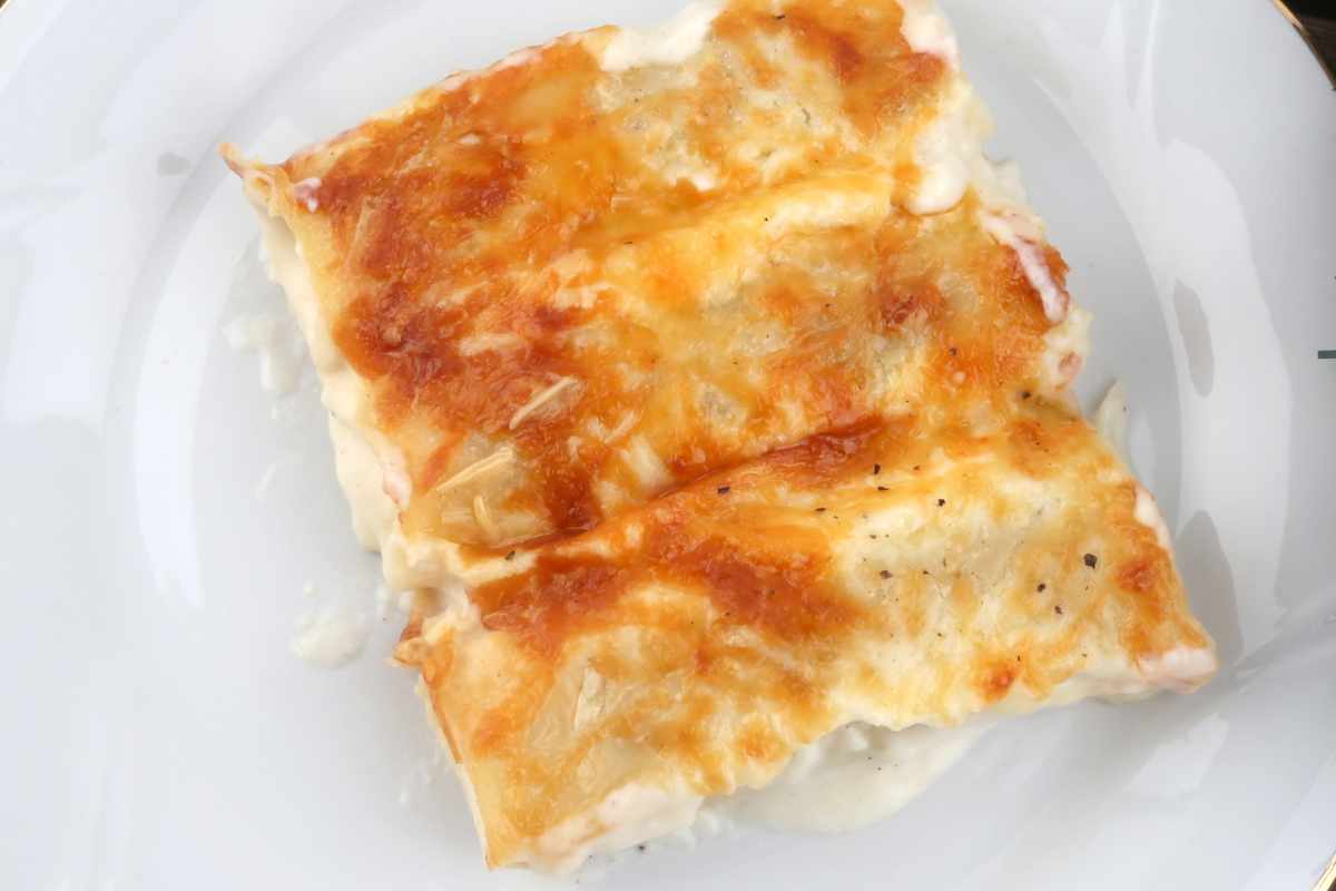 un piatto con dentro cannelloni patate e funghi visto dall'alto