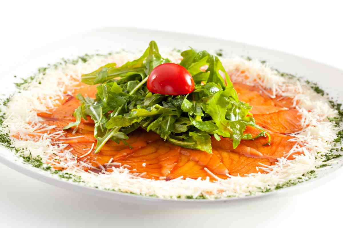 Carpaccio al salmone con rucola in un piatto