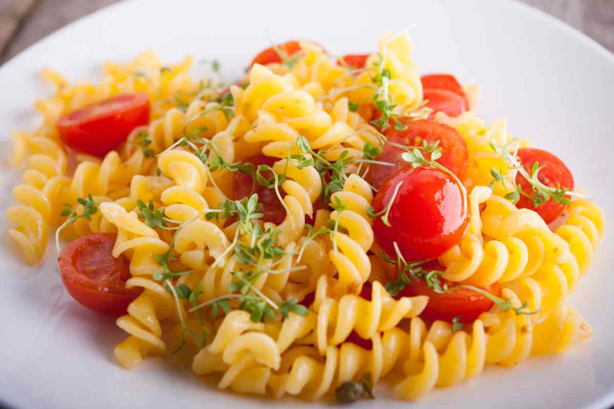Fusilli con pomodorini e germogli in un piatto