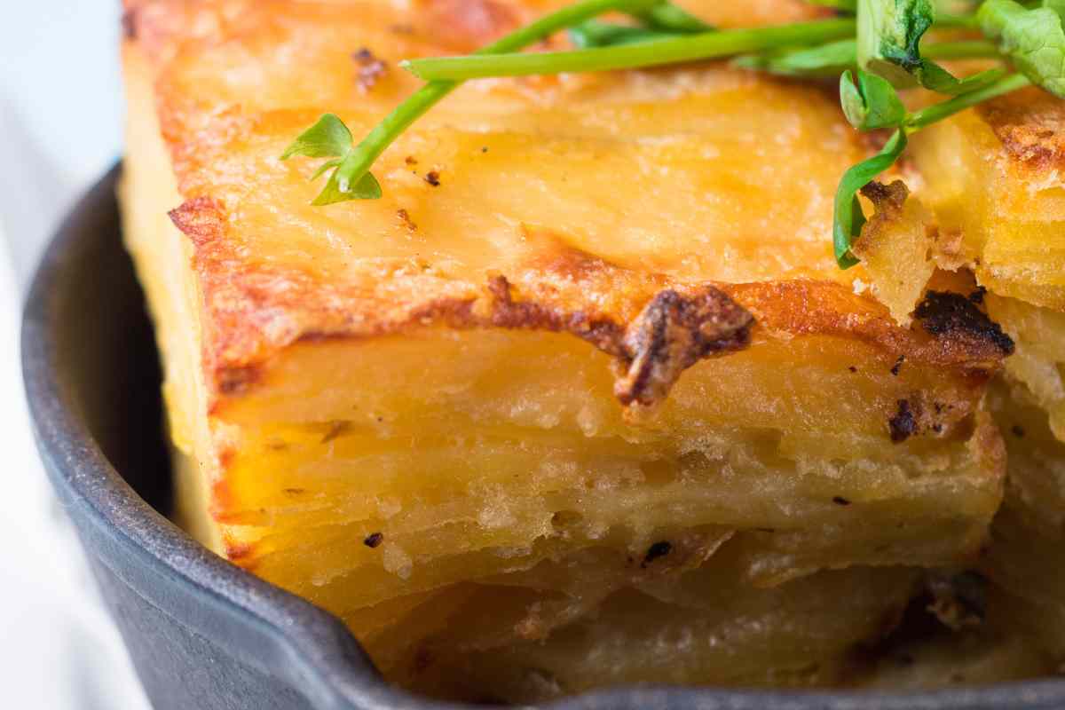 primo piano di un tortino multisfoglia di patate e provola appena uscito dal forno