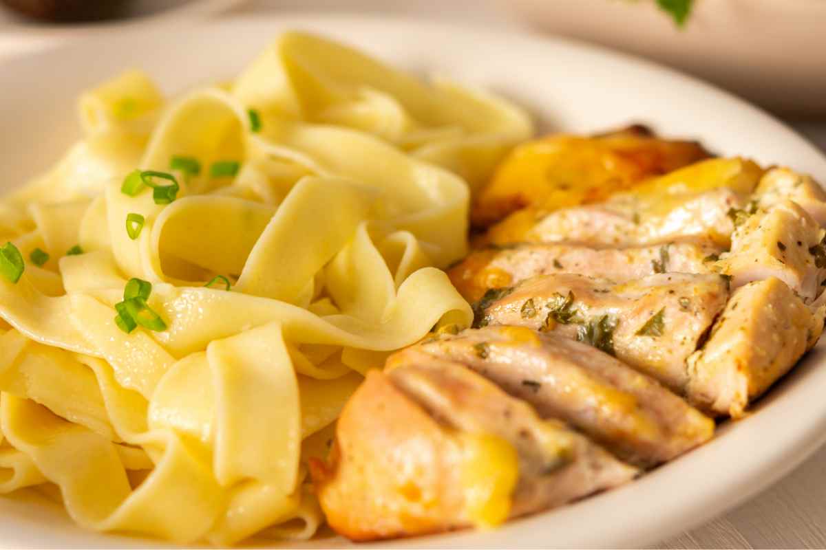 Pappardelle al burro con petto di pollo in un piatto