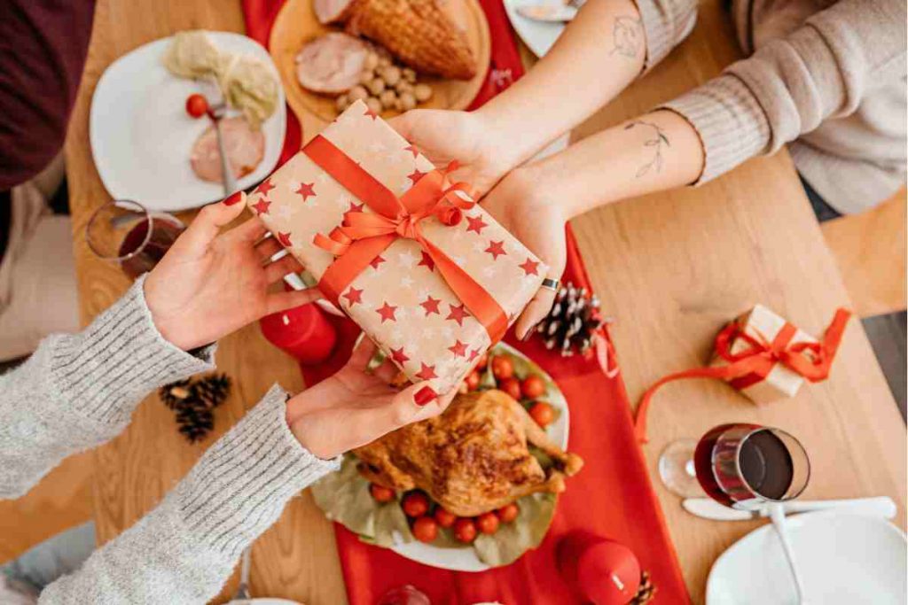 due persone si scambiano un regalo di Natale a tavola