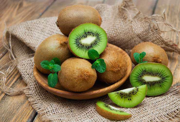 ciotola con kiwi intero e tagliato