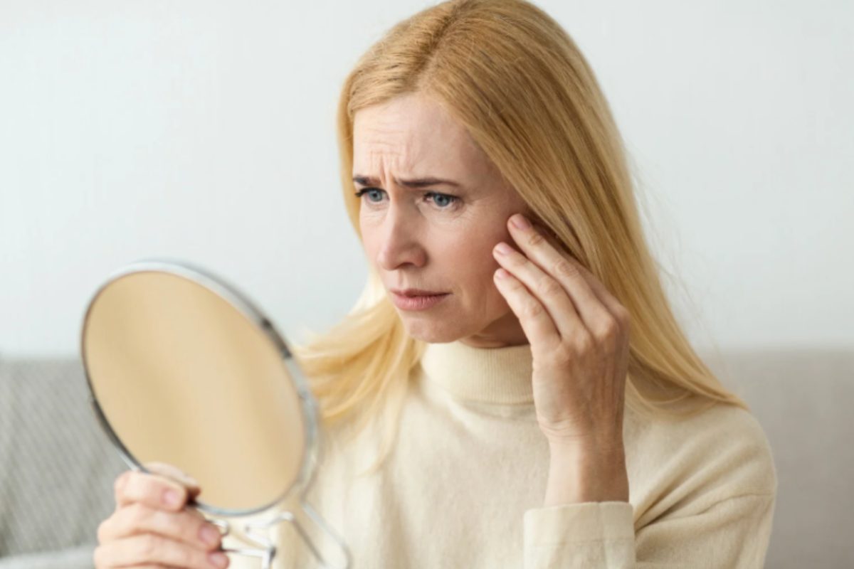 donna che si controlla le rughe allo specchio