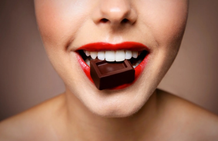 donna che mangia un quadratino di cioccolato