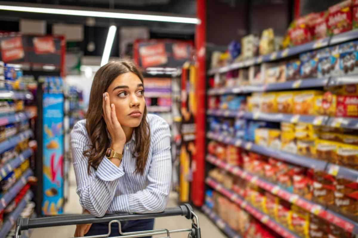 donna al supermercato con espressione triste