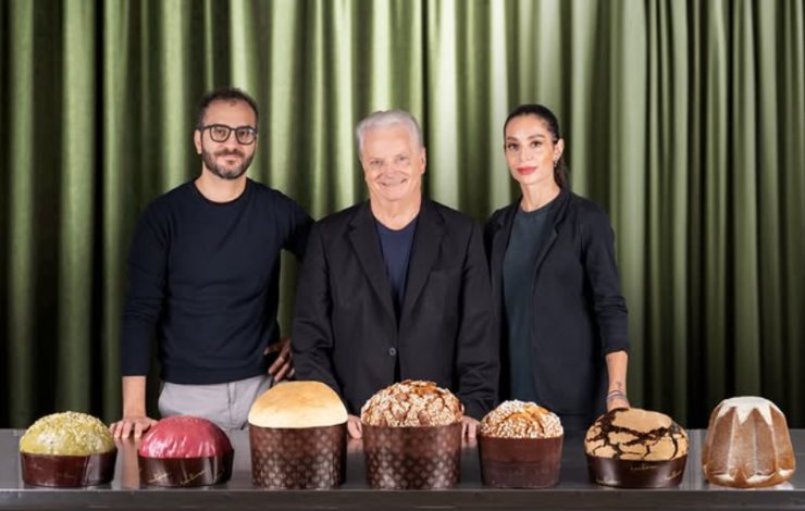 iginio massari in mezzo ai due figli con davanti tutti i loro dolci di natale