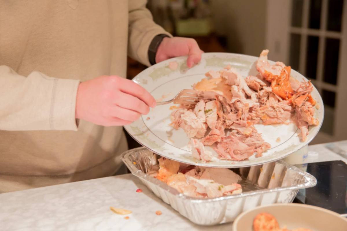 donna che getta via degli avanzi di carne