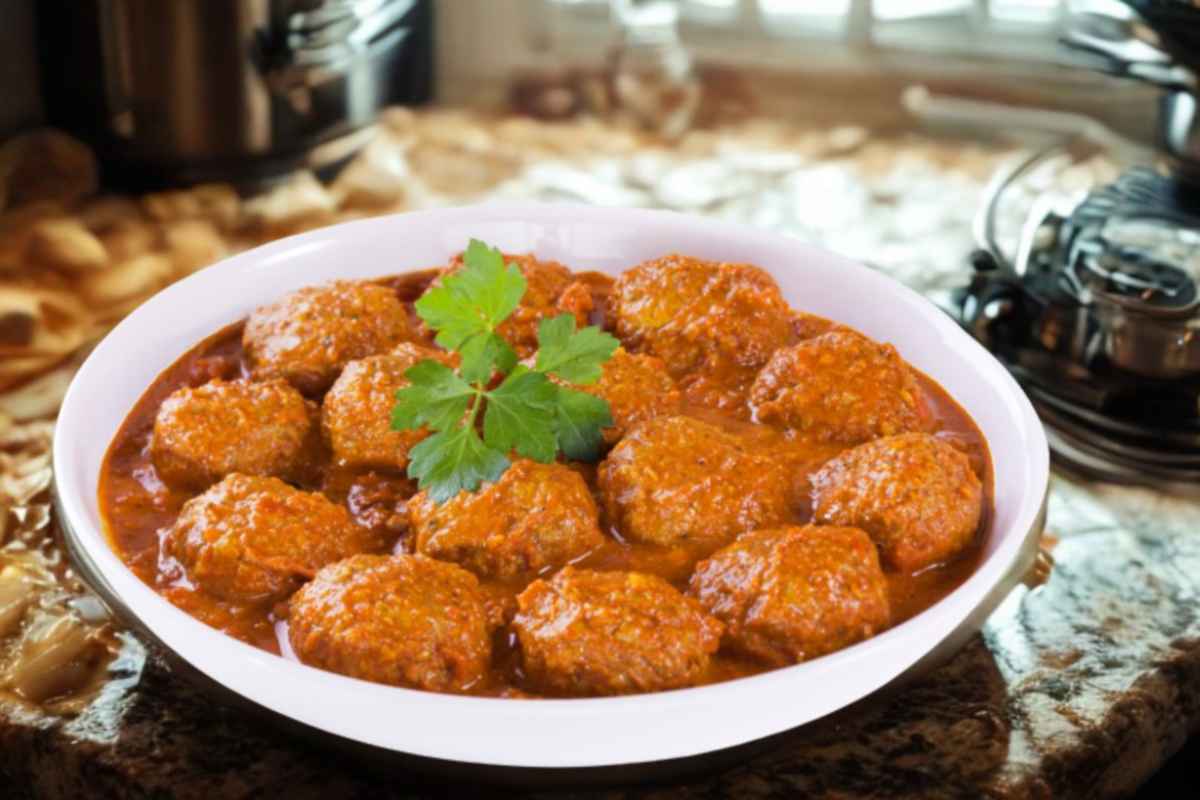 polpette al sugo dentro ad un recipiente bianco