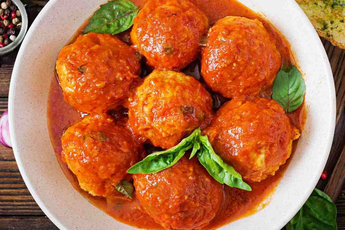 piatto di polpette al sugo con foglie di basilico