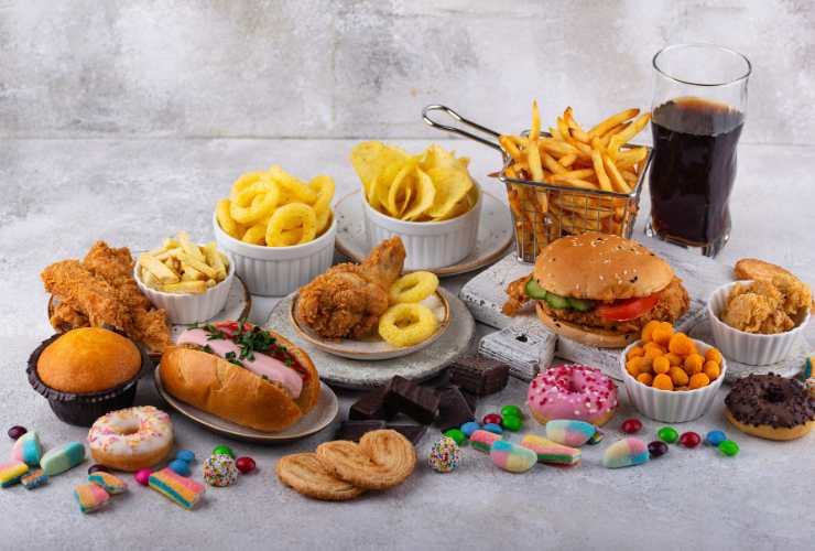 assortimento di "cibi spazzatura": patatine fritte, dolci, hot dog, snack.