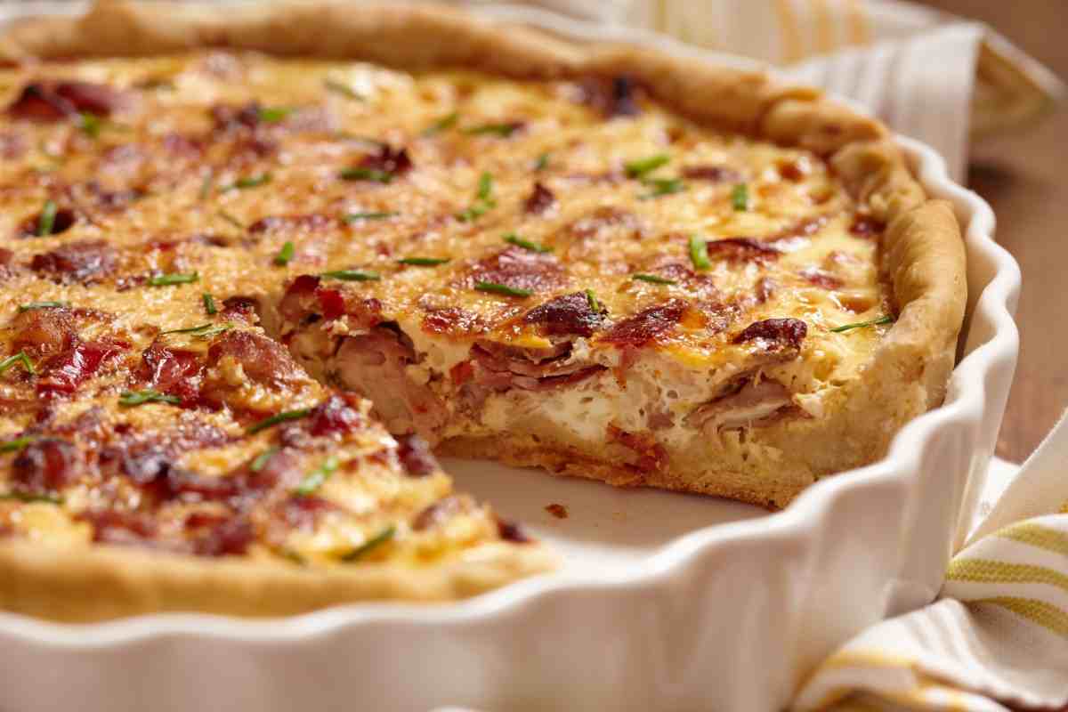 Quiche con pancetta senza una fetta in una teglia