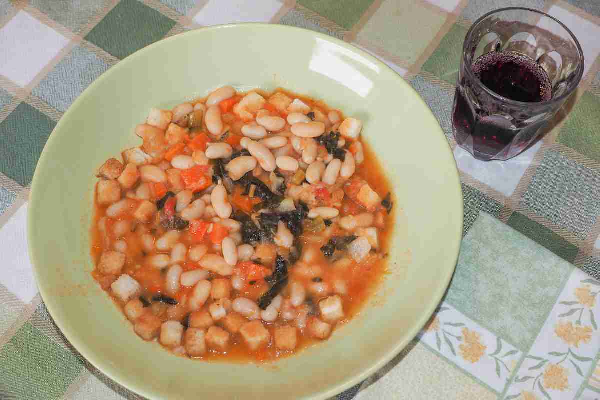 Ribollita toscana in un piatto con un bicchiere di vino