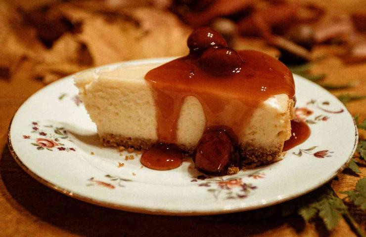 fetta di cheesecake con topping di ciliegie in un piattino
