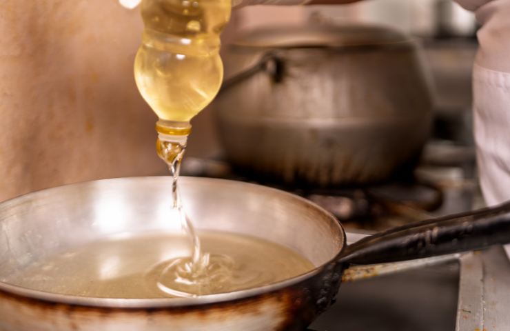 Olio di semi per friggere versato in padella