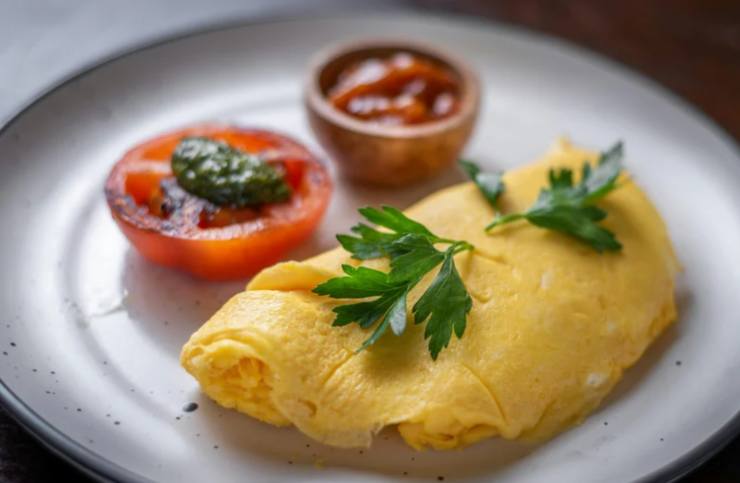 frittata in un piatto con pomodori e salsa rossa