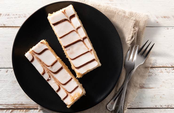 Due fette di torta millefoglie alla crema pasticciera a ragnatela