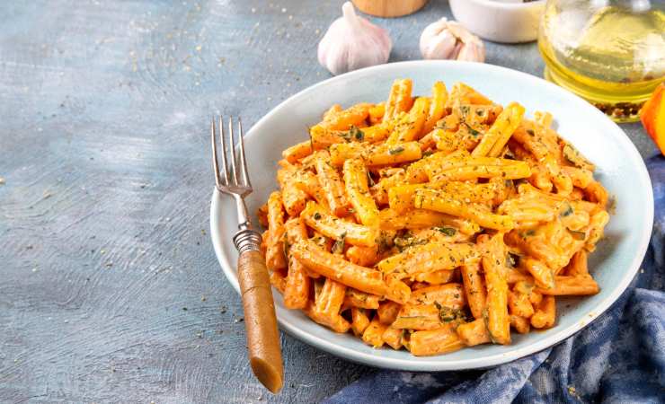 piatto di pasta con crema di zucca e forchetta