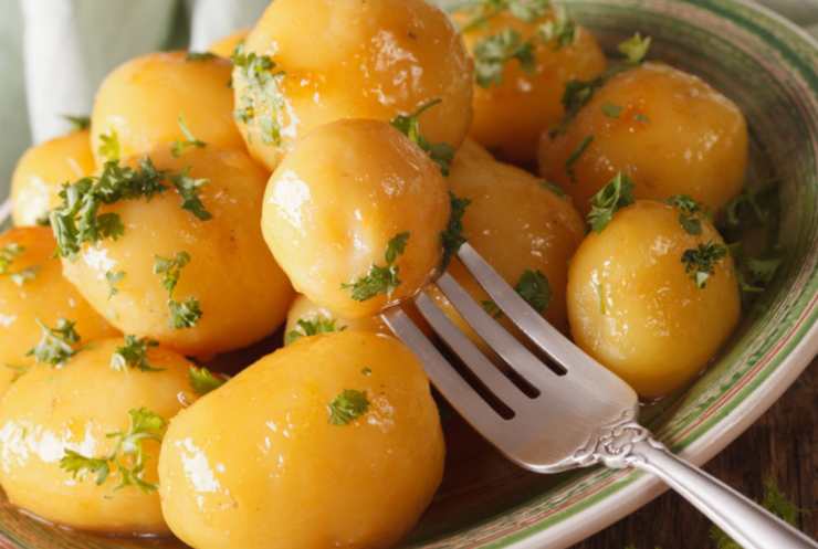 patate caramellate insaporite con aromi in piatto con forchetta