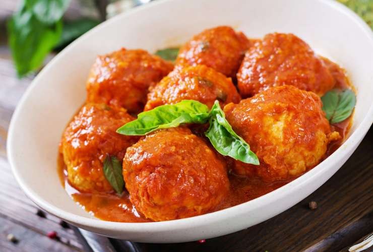 piatto di polpette al sugo con foglie di basilico