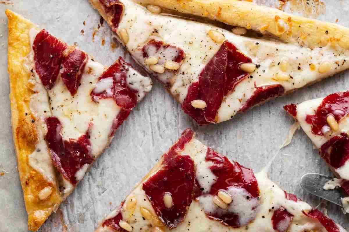 Sfogliata salata con bresaola, formaggio cremoso e pinoli tagliata a fette