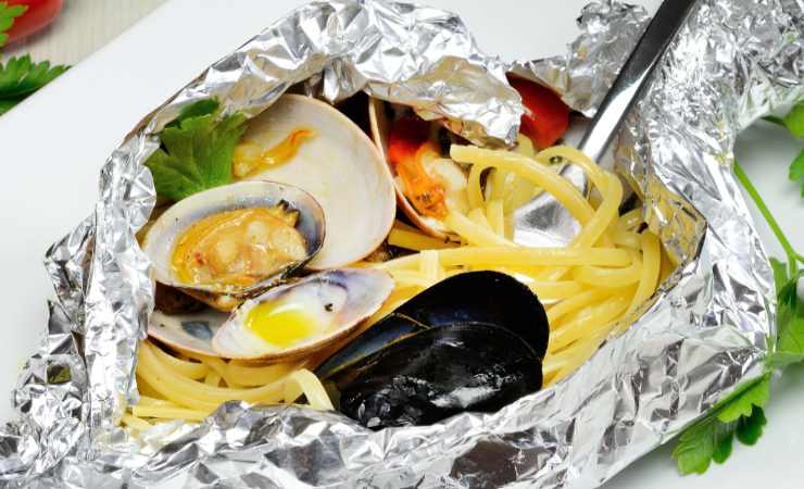 spaghetti al cartoccio con frutti di mare e forchetta