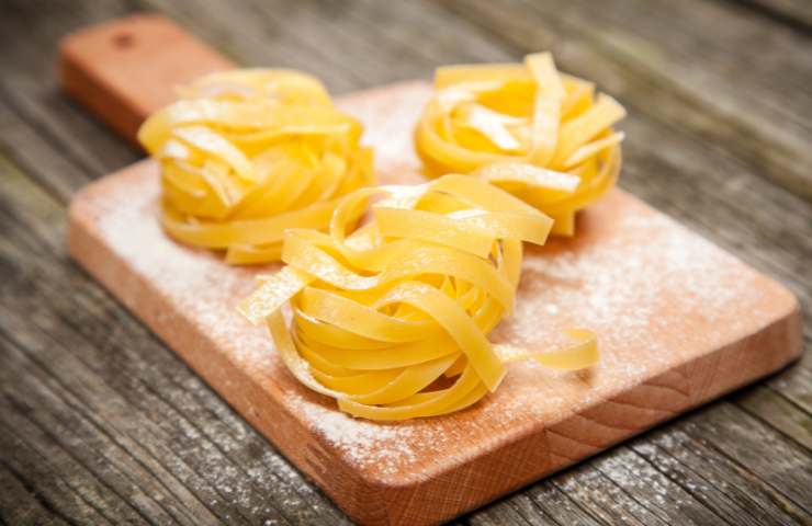 Nidi di tagliatelle su un tagliere di legno