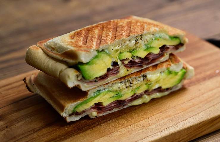 Due fette di torta salata di pasta sfoglia con avocado e formaggio sovrapposte