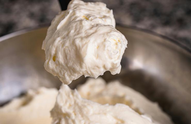Ricotta mescolata a zucchero a velo in un contenitore metallico