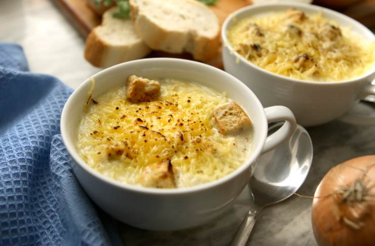 zuppa di cipolle in piatto bianco con pane