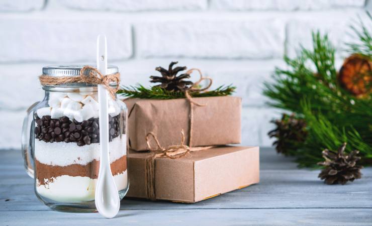 vasetto di vetro con ingredienti per dolci e pacchetti regalo