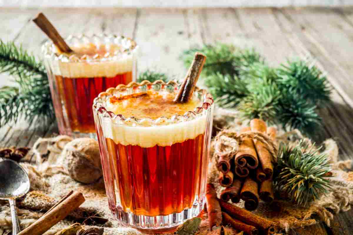 Due bicchieri di rum caldo al burro su tavola decorata per Natale